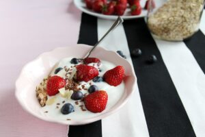 Ciotola di yogurt greco con frutta fresca e noci, ideale per una colazione energizzante.