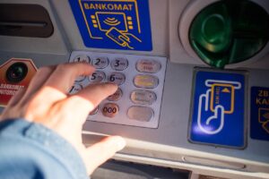 Bancomat con simbolo di commissione, evidenziando l'aumento di 2 euro dal febbraio 2024.