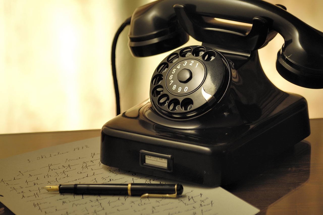 Un vecchio telefono fisso vintage su un tavolo, evidenziando il suo design originale e affascinante.